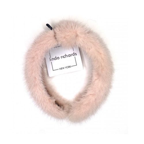 A blush mink fur headband with a knot in the middle. The label has black text that reads “linda richards NEW YORK.”