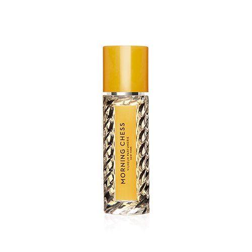 A travel size perfume bottle with a  yellow cap, label and black lettering.