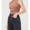 Model wearing skintone one-shoulder bodysuit with black denim jeans.